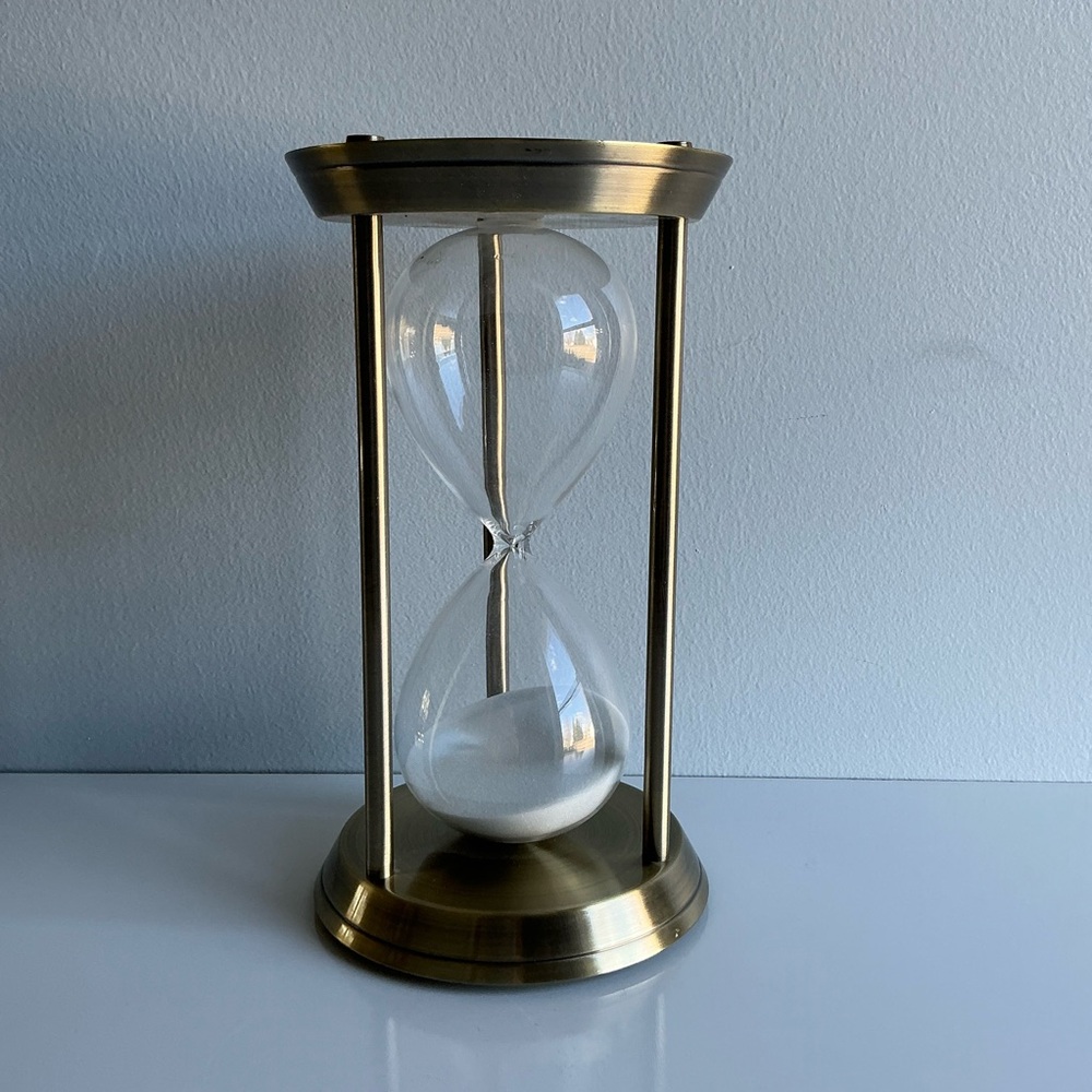 Brushed brass-tone hourglass with three columns glass with white sand 12.25” B2